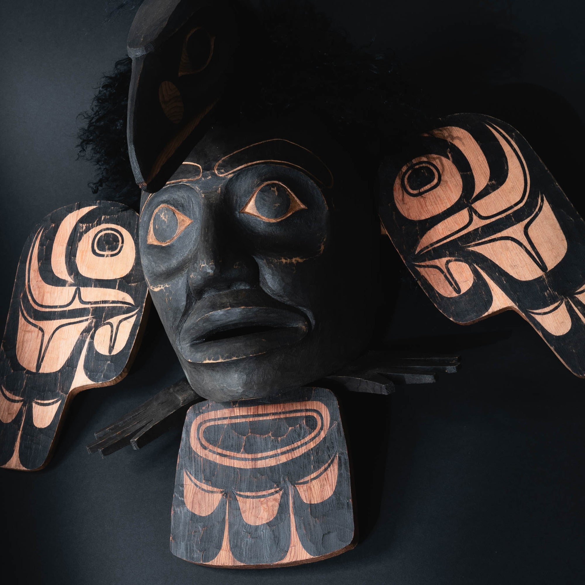 Close-up of a decorative mask with face, two eyes, a nose, and a mouth.