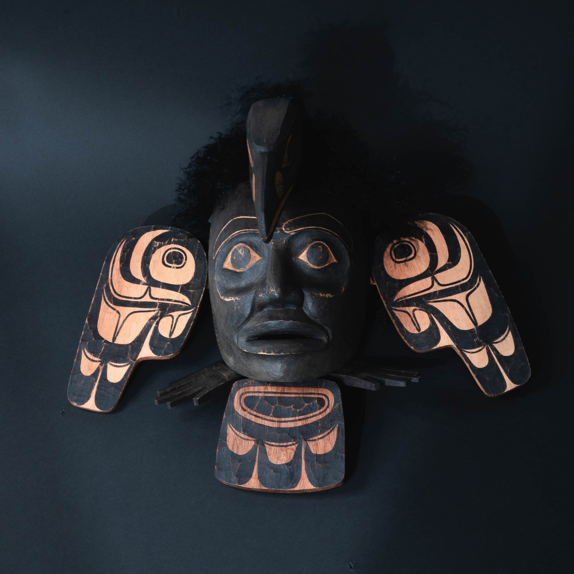Decretive northwest coast wall hanging with black face and wings.