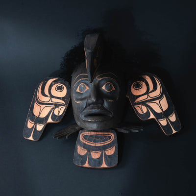 Decretive northwest coast wall hanging with black face and wings.