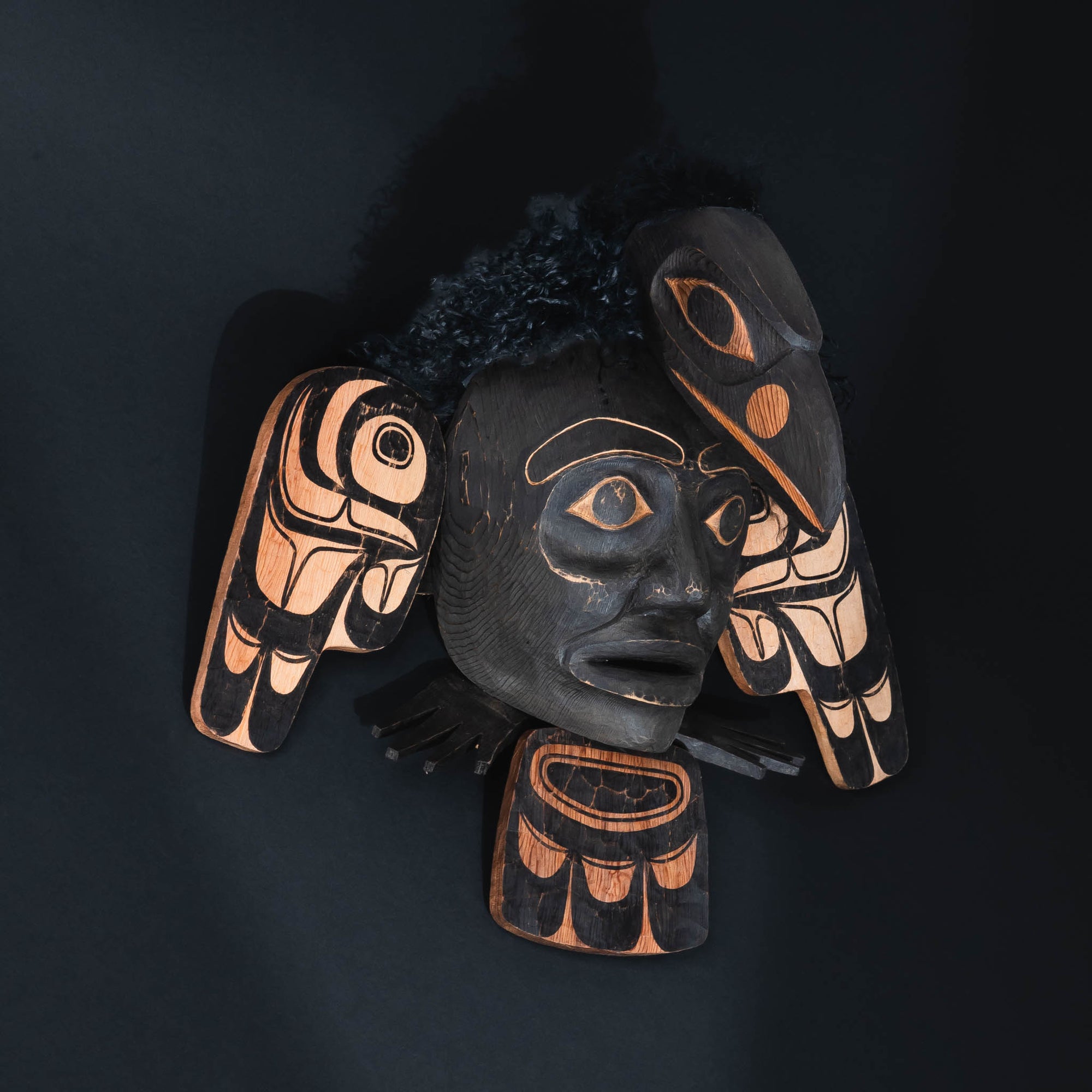 Articulated raven Haida art mask by Corey Bulpitt on a black background.