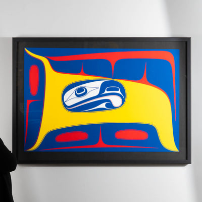 Framed Bird in the Air limited art print by Haida artist Robert Davidson on a white wall with a cropped model on the left.