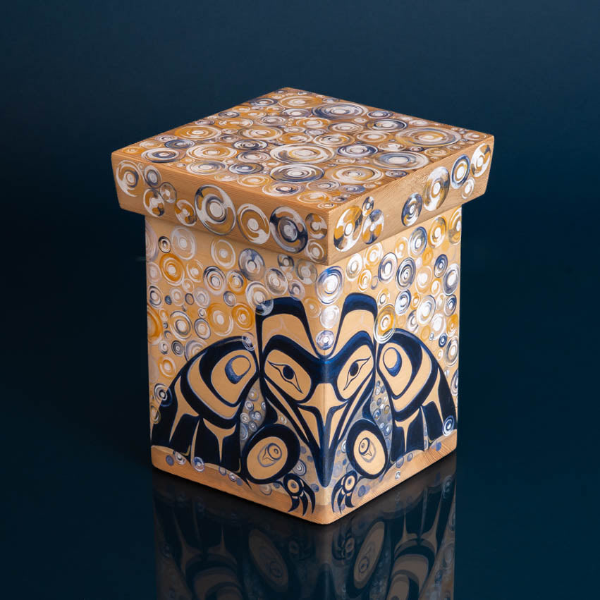 Decrotive wooden box painted with formline raven in blue and black, and bubbles in blues whites and yellows, on a blue back ground