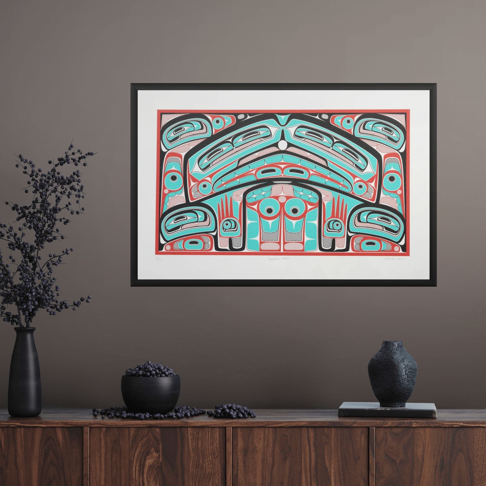 Framed artwork Colorful abstract formline chiefs chair design with geometric haida patterns  framed on a wall above a wooden console table.