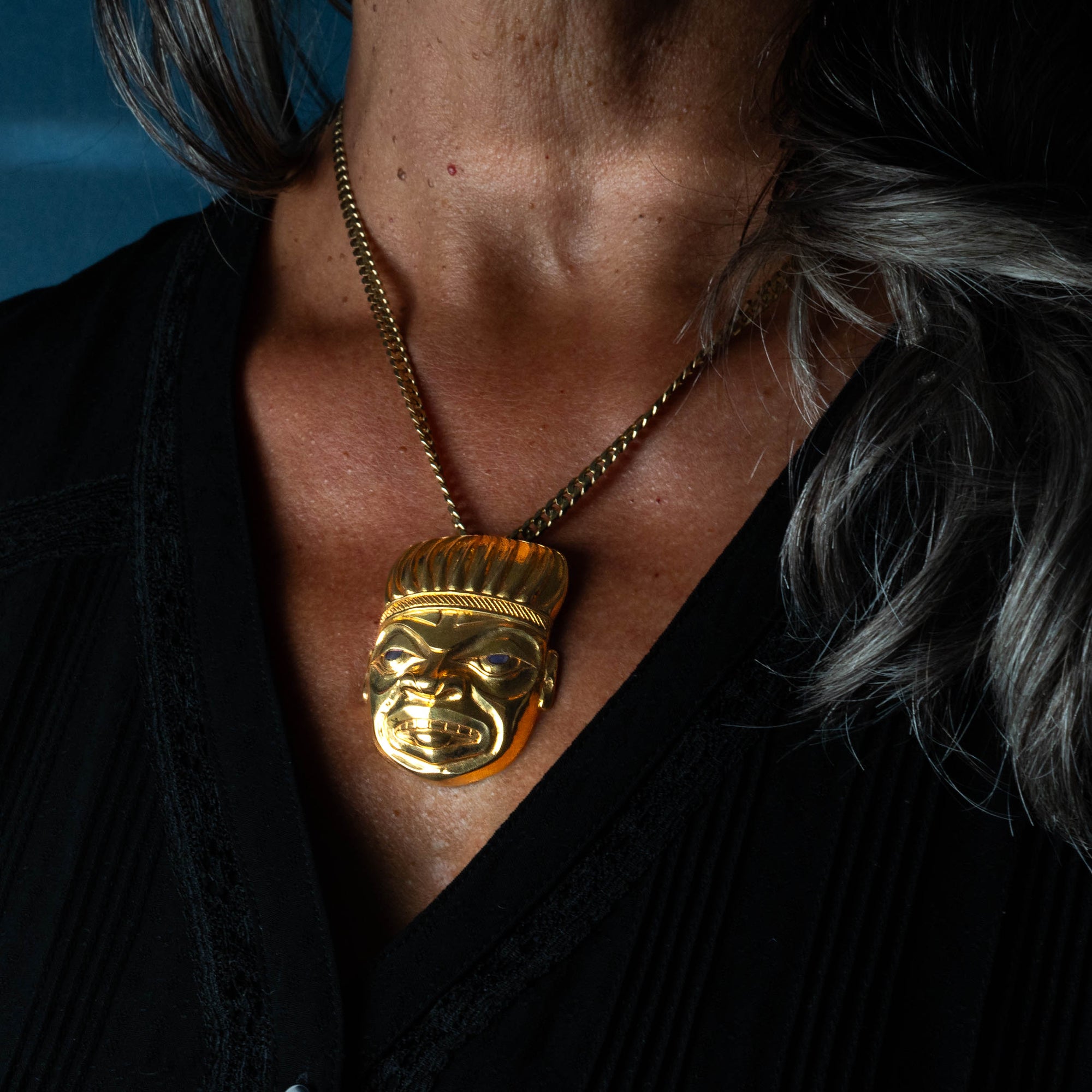 Gold shaman necklace with worn by a woman model with grey hair and a black shirt