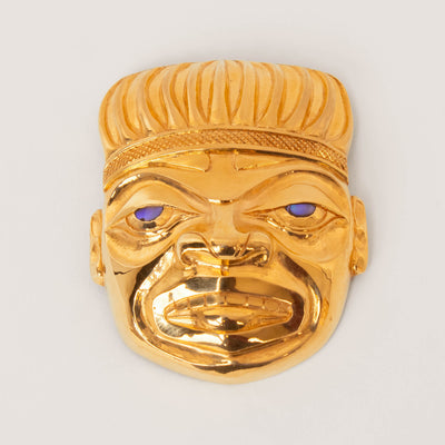 Gold human pendant with blue eyes on a white background