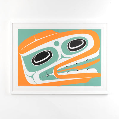 White Framed artwork of a stylized Haida Formline Halibut face with orange, green, and black colors framed and ready to hang by Cori Savard