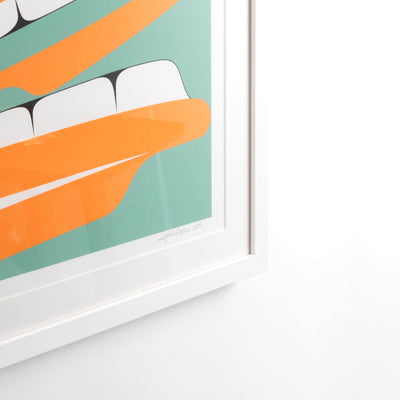 Corner of white Framed artwork of a stylized Haida Formline Halibut face with orange, green, and black colors framed and ready to hang by Cori Savard