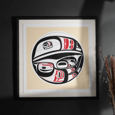 Framed artwork of a First Nations Raven with red and white accents on a beige background.