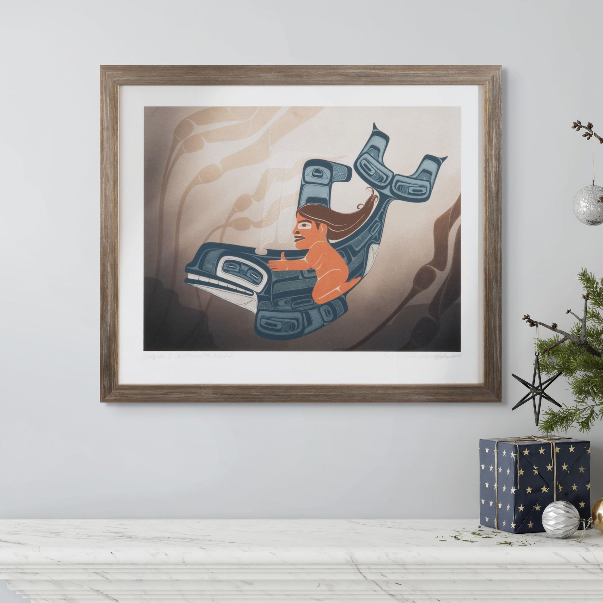 Framed artwork of fine art print a moment to vanish created by local haida artist Shoshannah Greene featuring a gilr riding a formline killer whale through a kelp bedwith abstract design on a wall.