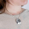 Haida Carver and Jeweller Alvin Adkins Sterling Silver Raven Pendant with 3mm curb chain on model side angle