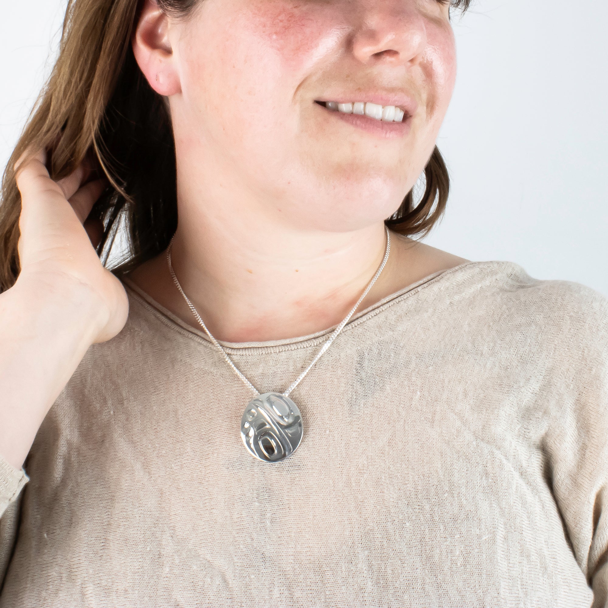 Haida Carver and Jeweller Alvin Adkins Sterling Silver Raven Pendant with 3mm curb chain on model