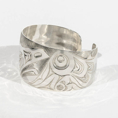 Right side of Sterling Silver Haida Raven bracelet with intricate formline designs showning the ravens wing hand carved by James Sayer Haida Jeweller on a white background