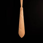 Wooden carved paddle on a black background.
