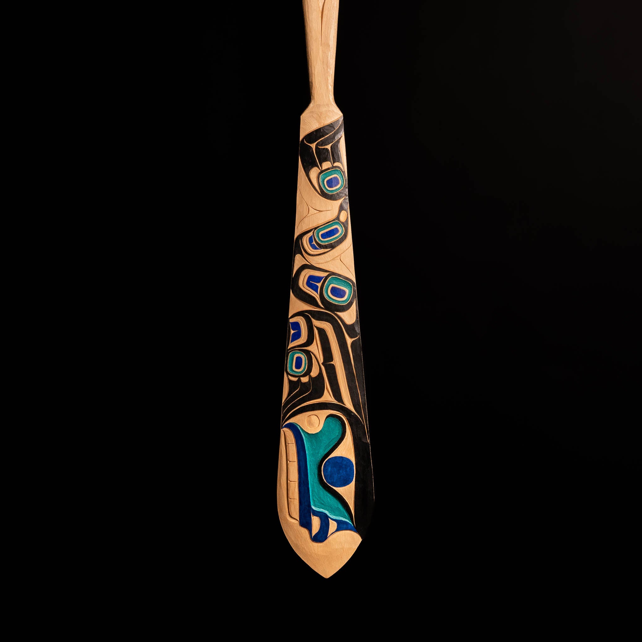 Tip of 'The Wayfinder' Haida Paddle Art by Billy Yovanovich on lack background.