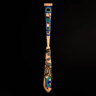 Decorative wooden paddle with intricate blue and black Haida patterns on a black background.