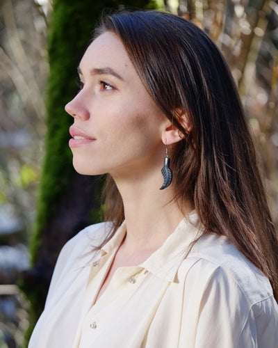 Model wearing Haida argillite feather earrings